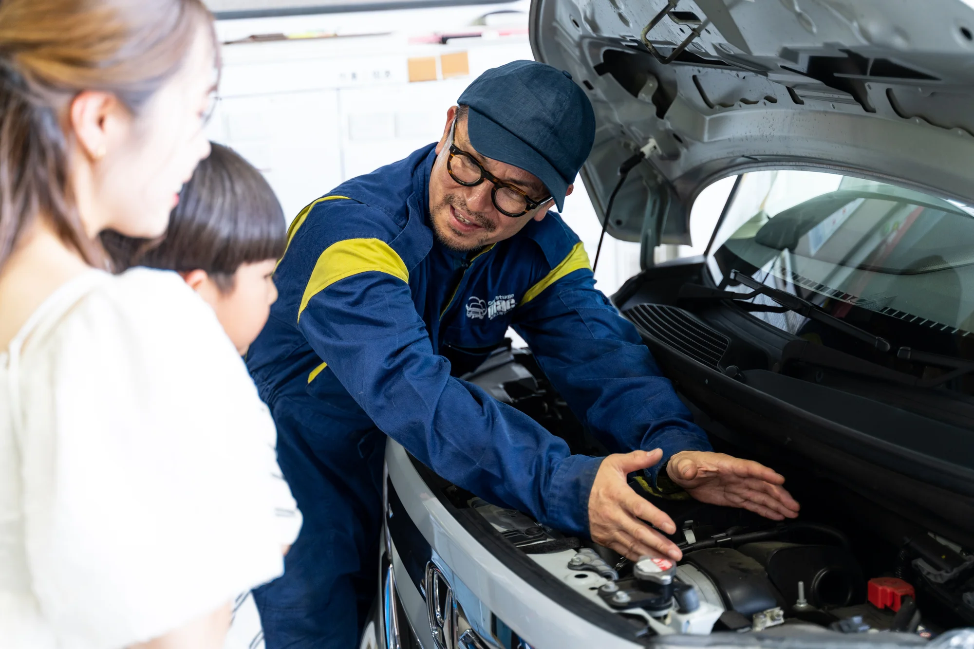 車を見ながら修理内容を説明するスタッフ